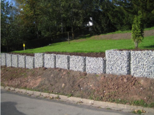 St&uuml;tzmauer aus Steink&ouml;rben an Stra&szlig;e zur Hangsicherung